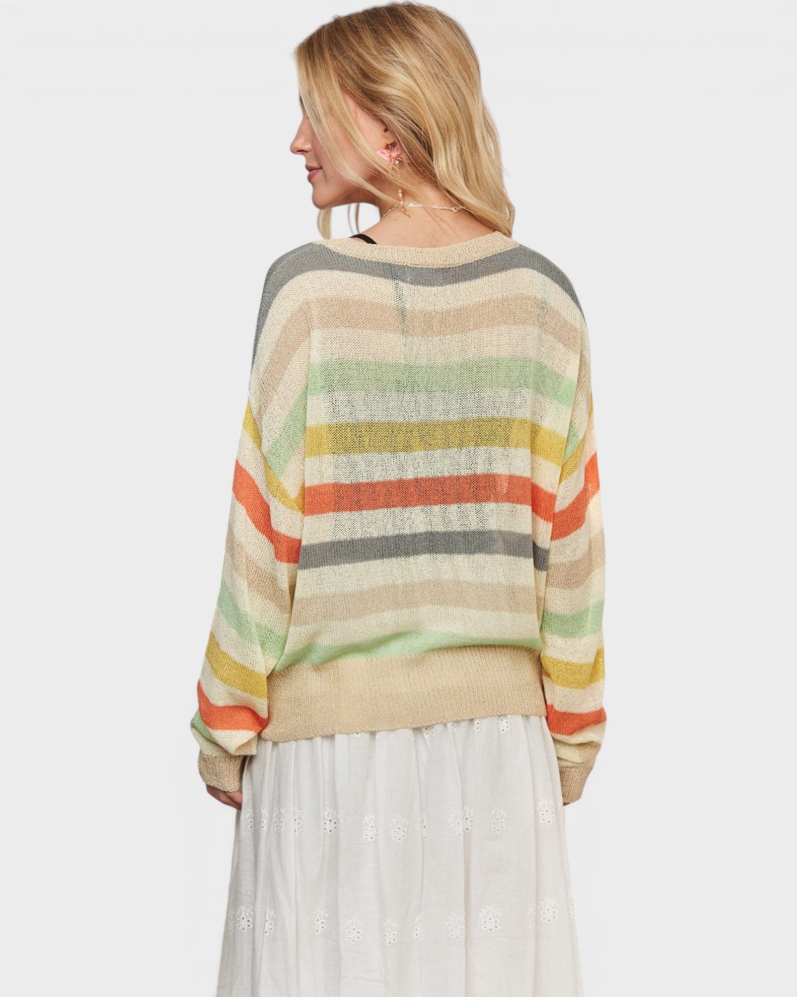 Woman wearing a colorful striped sweater on a white background