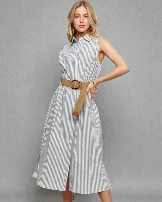 Woman wearing a striped dress with a belt on a gray background