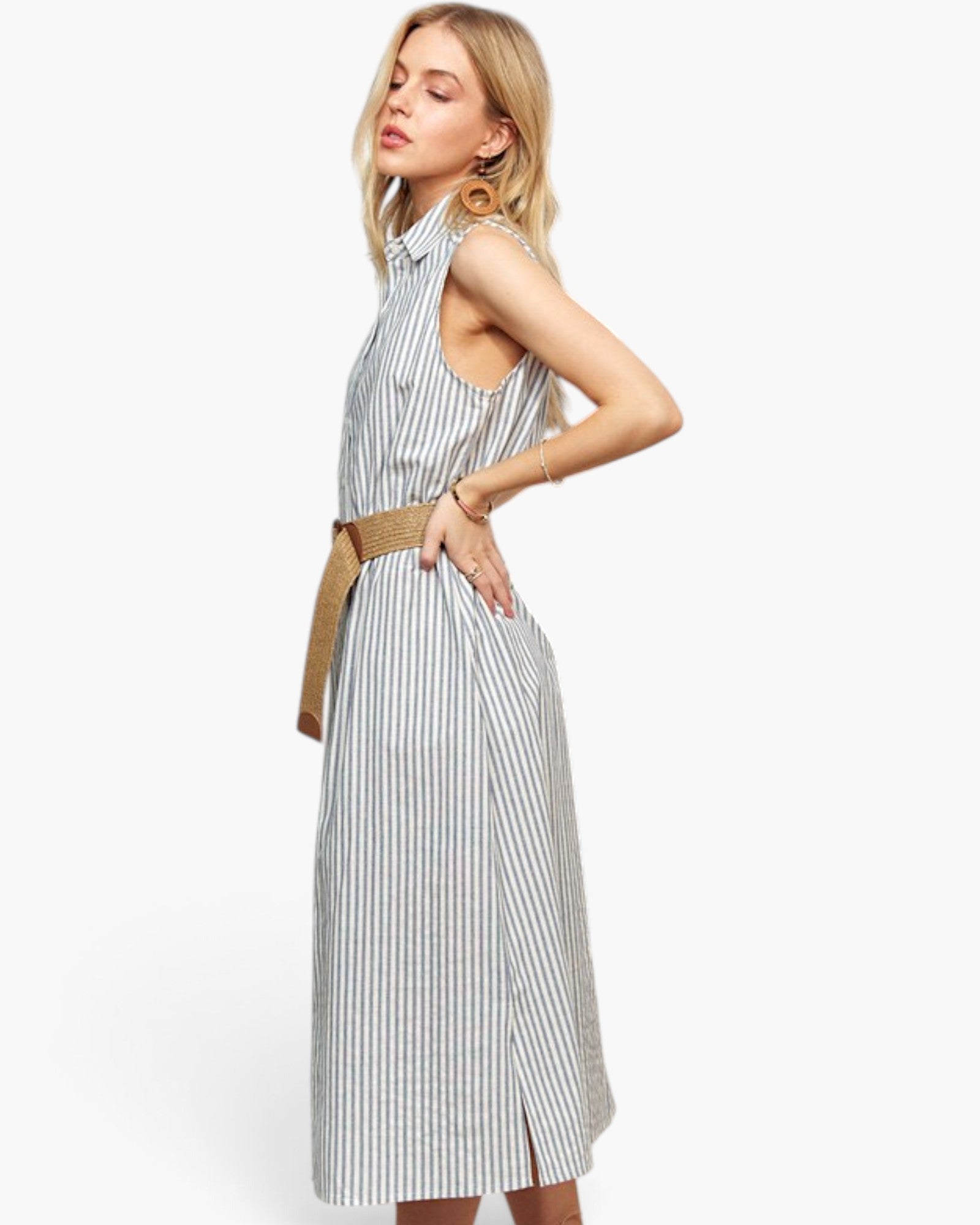 A woman modeling a sleeveless high-neck midi dress with vertical blue and white stripes, styled with a tan belt, against a plain white studio background.