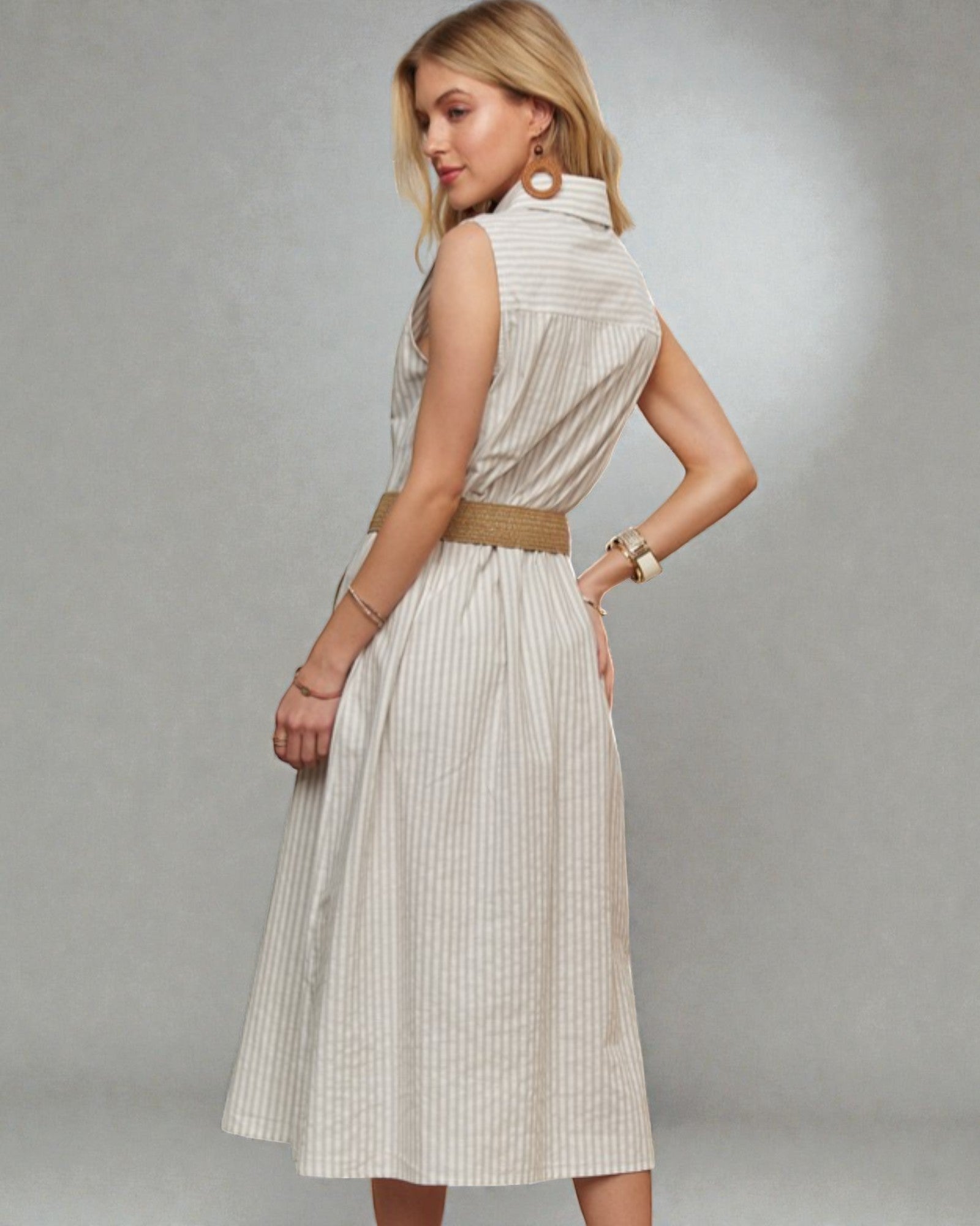 Woman wearing a white dress with vertical stripes on a gray background