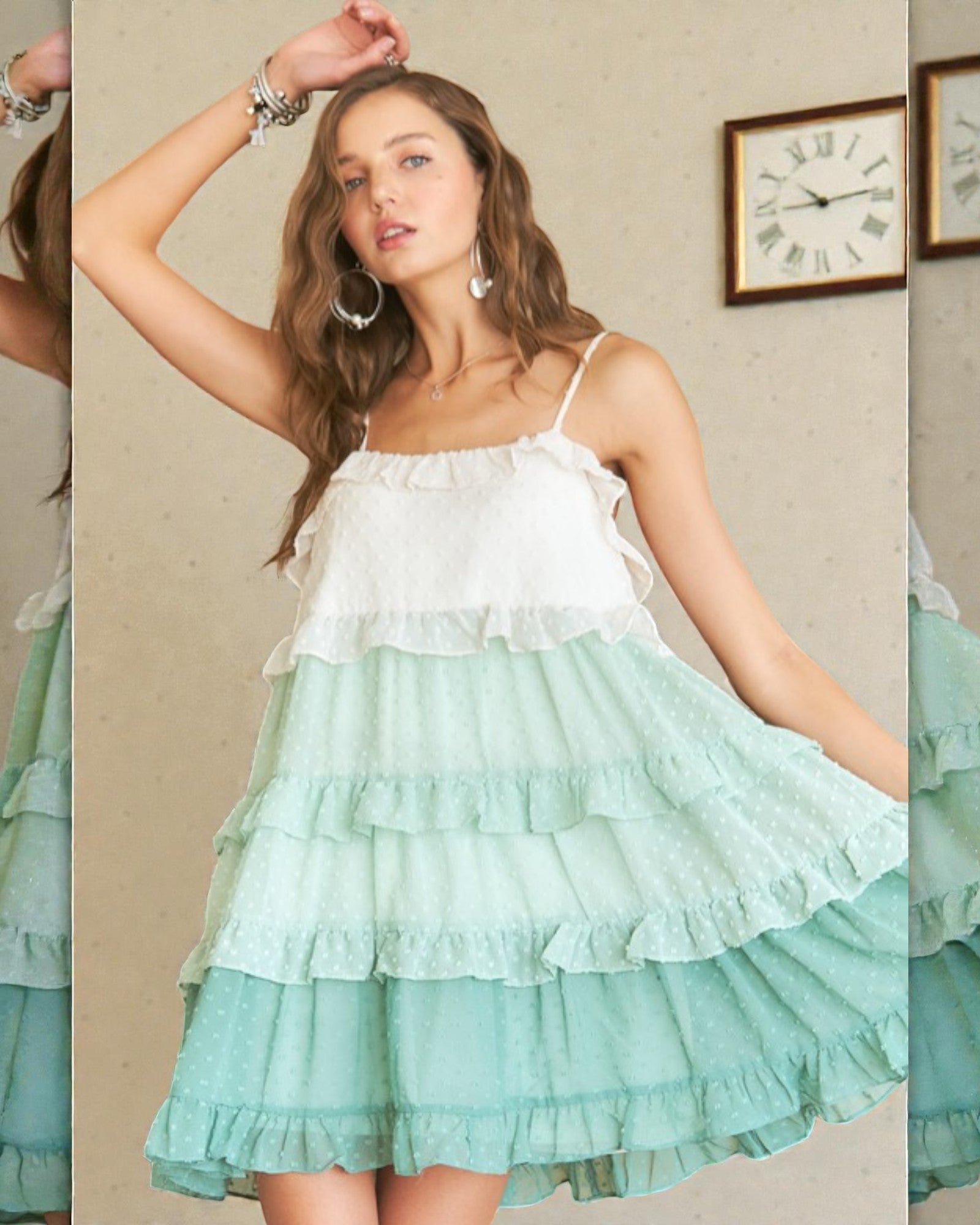 Woman wearing a white and green tiered dress in a room with a clock on the wall.