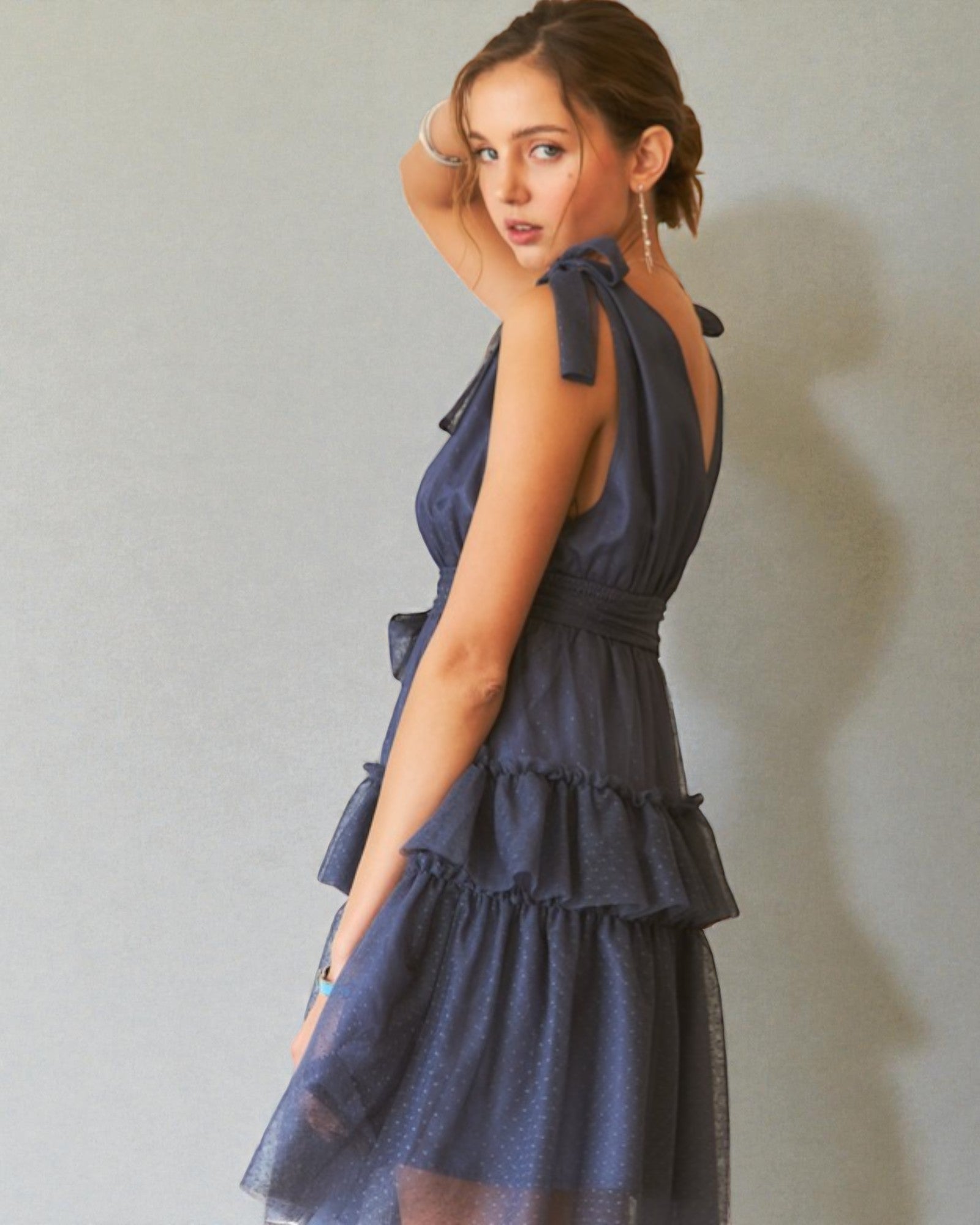 Woman wearing a navy blue dress against a plain background