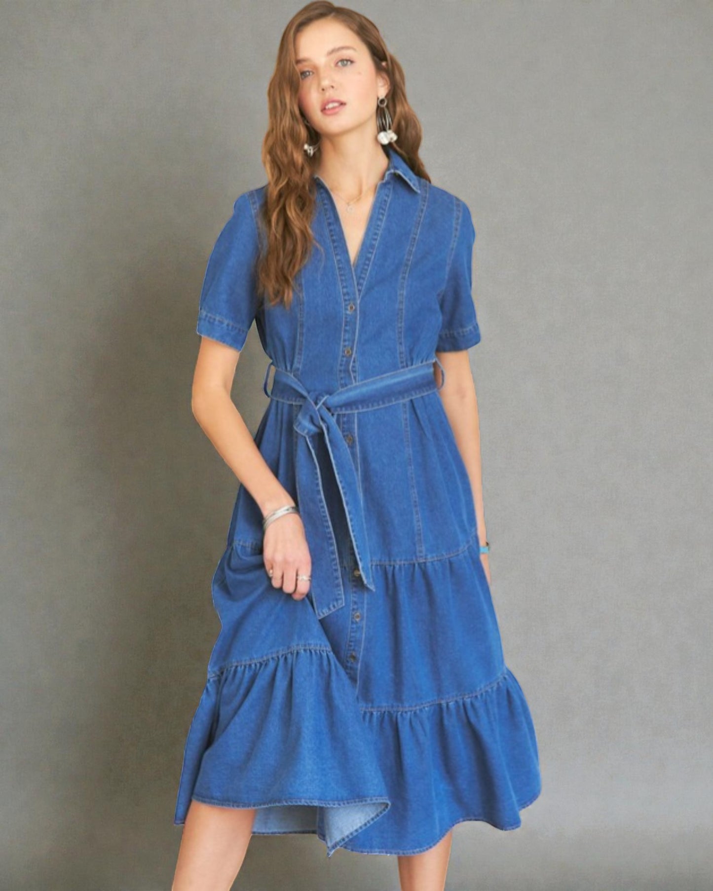 Woman wearing a blue denim dress against a gray background