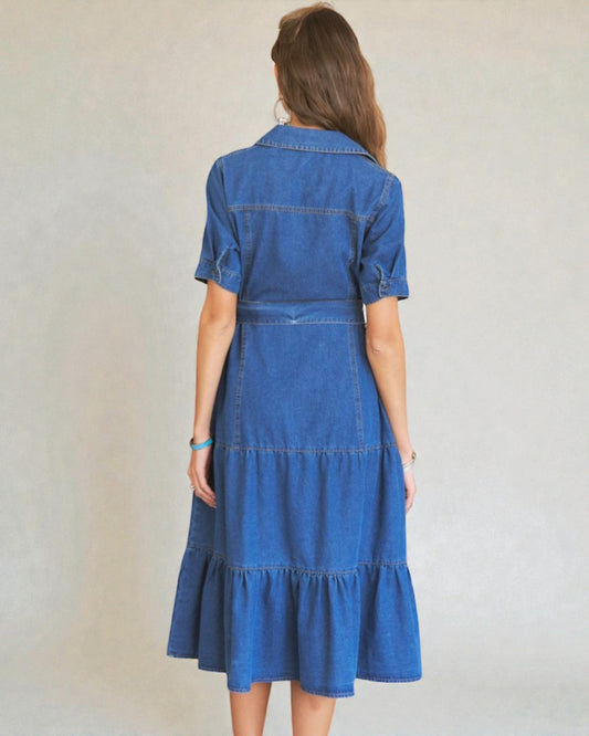 Woman wearing a blue denim dress against a plain background