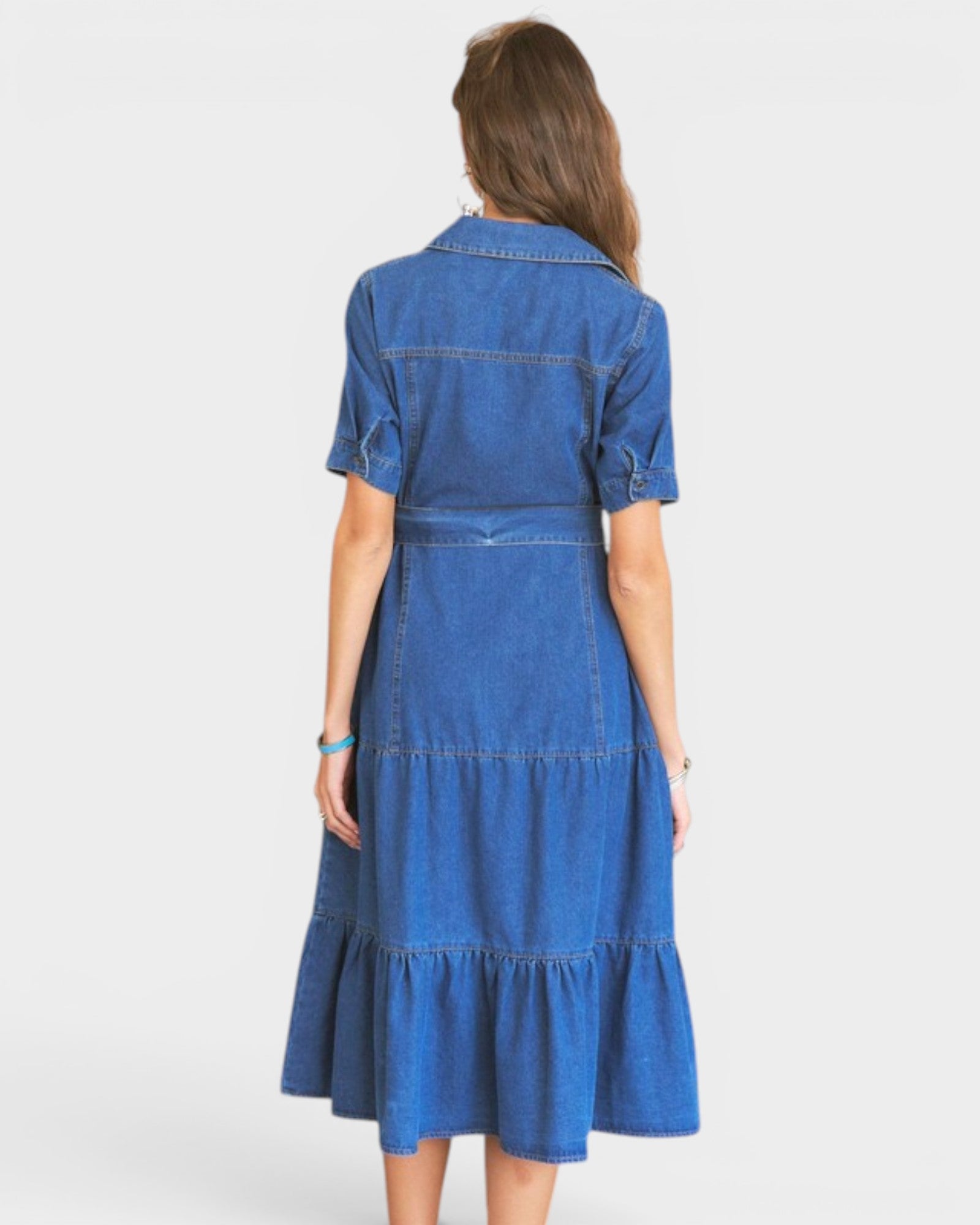 Woman wearing a blue denim dress on a white background