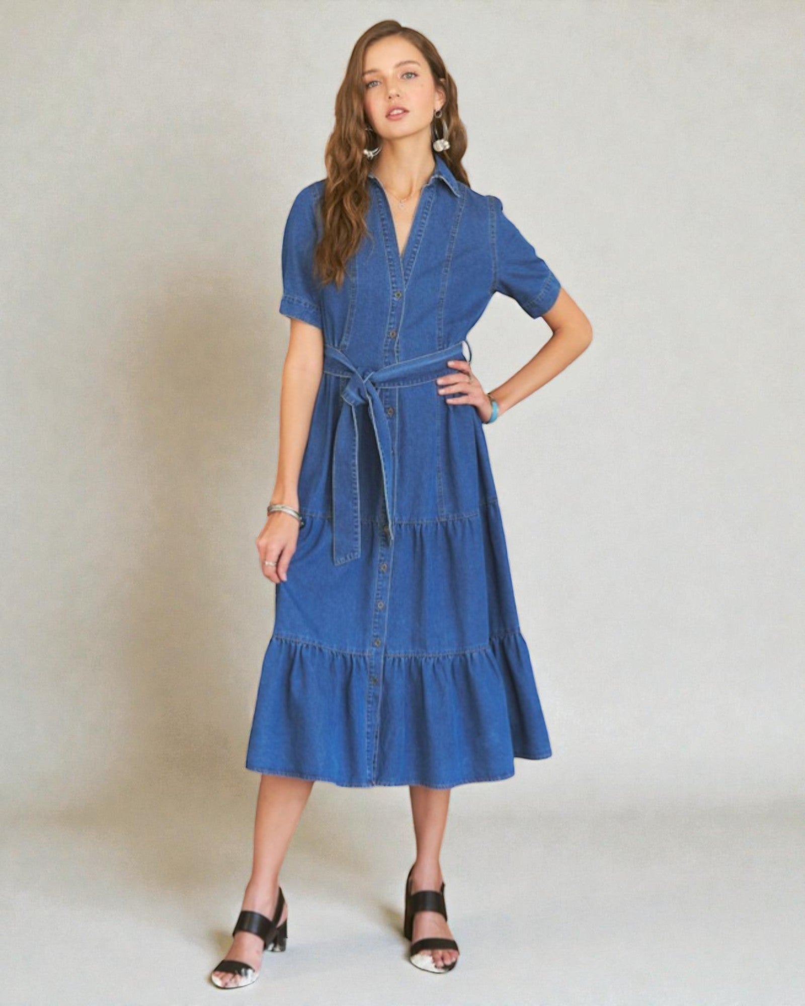 Woman wearing a blue denim dress against a plain background