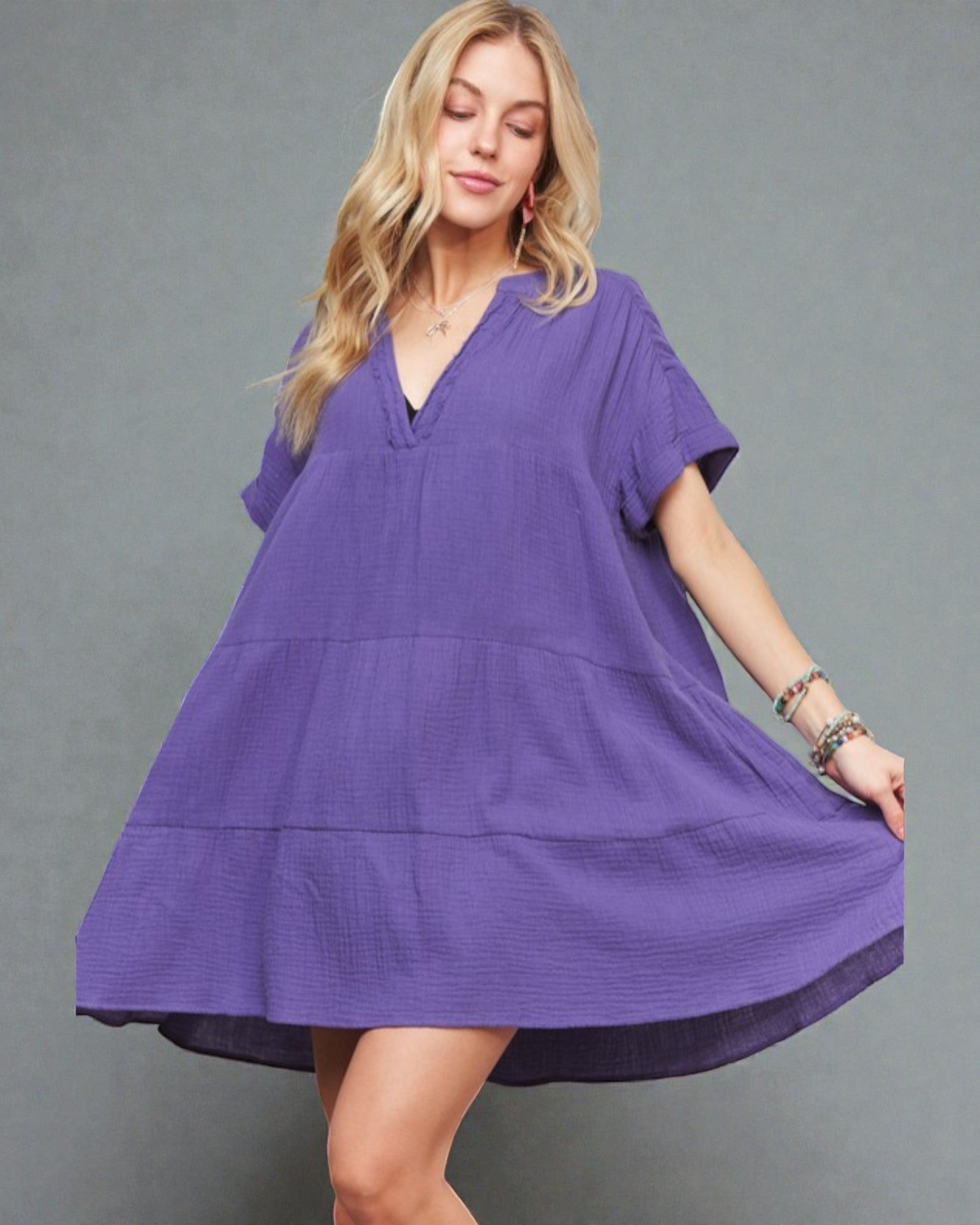 Woman wearing a purple dress against a gray background