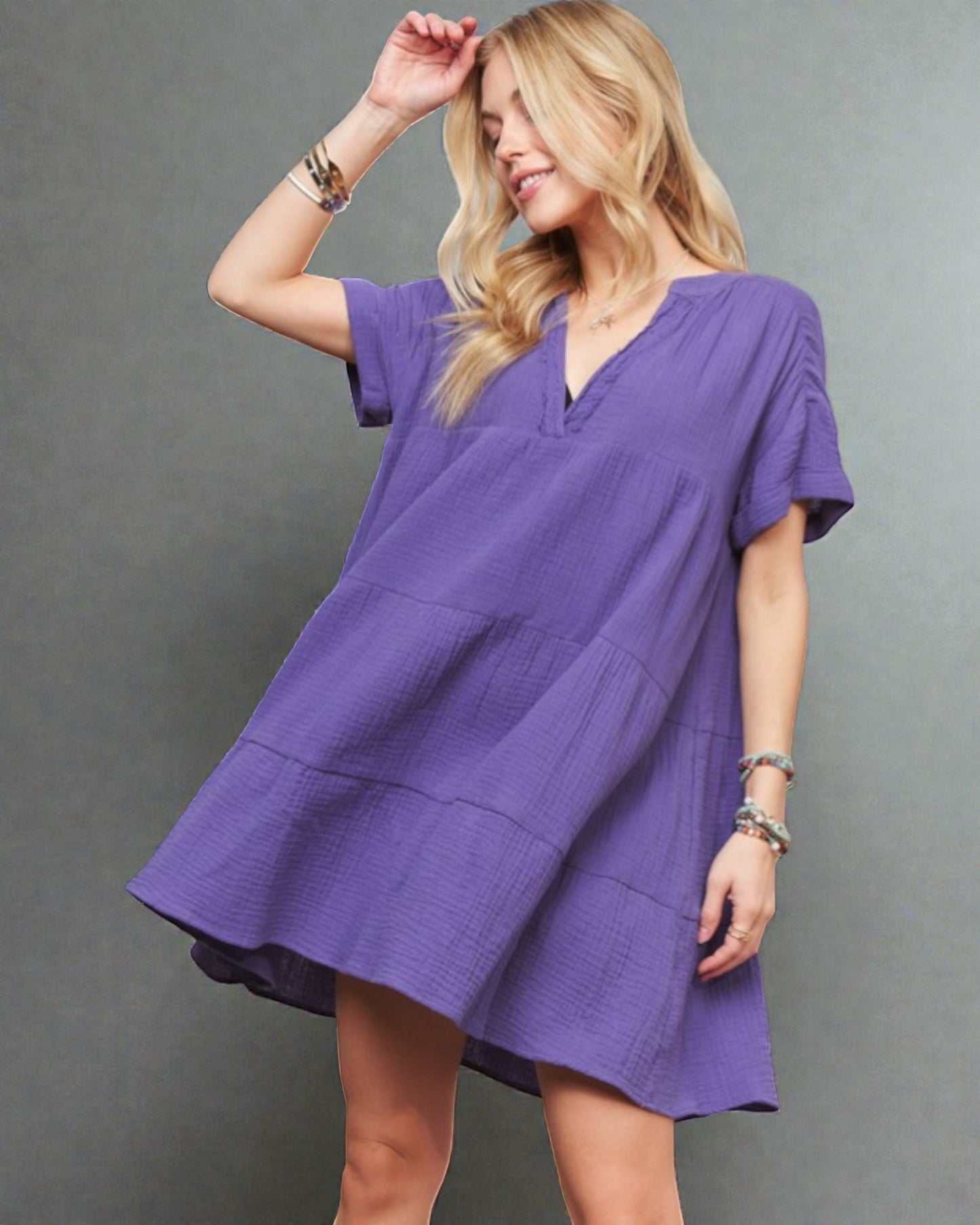 Woman wearing a purple dress against a gray background