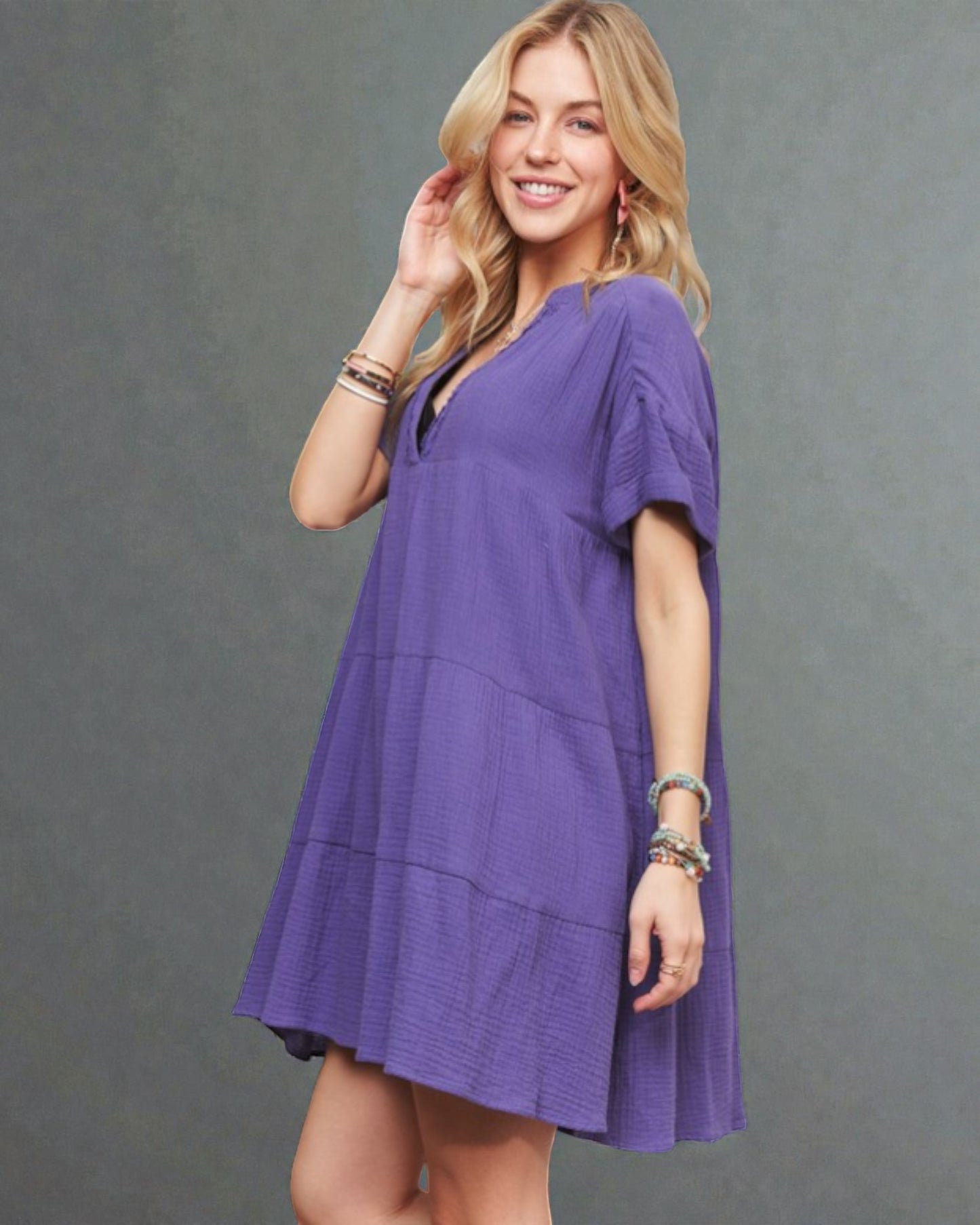 Woman wearing a purple dress against a gray background