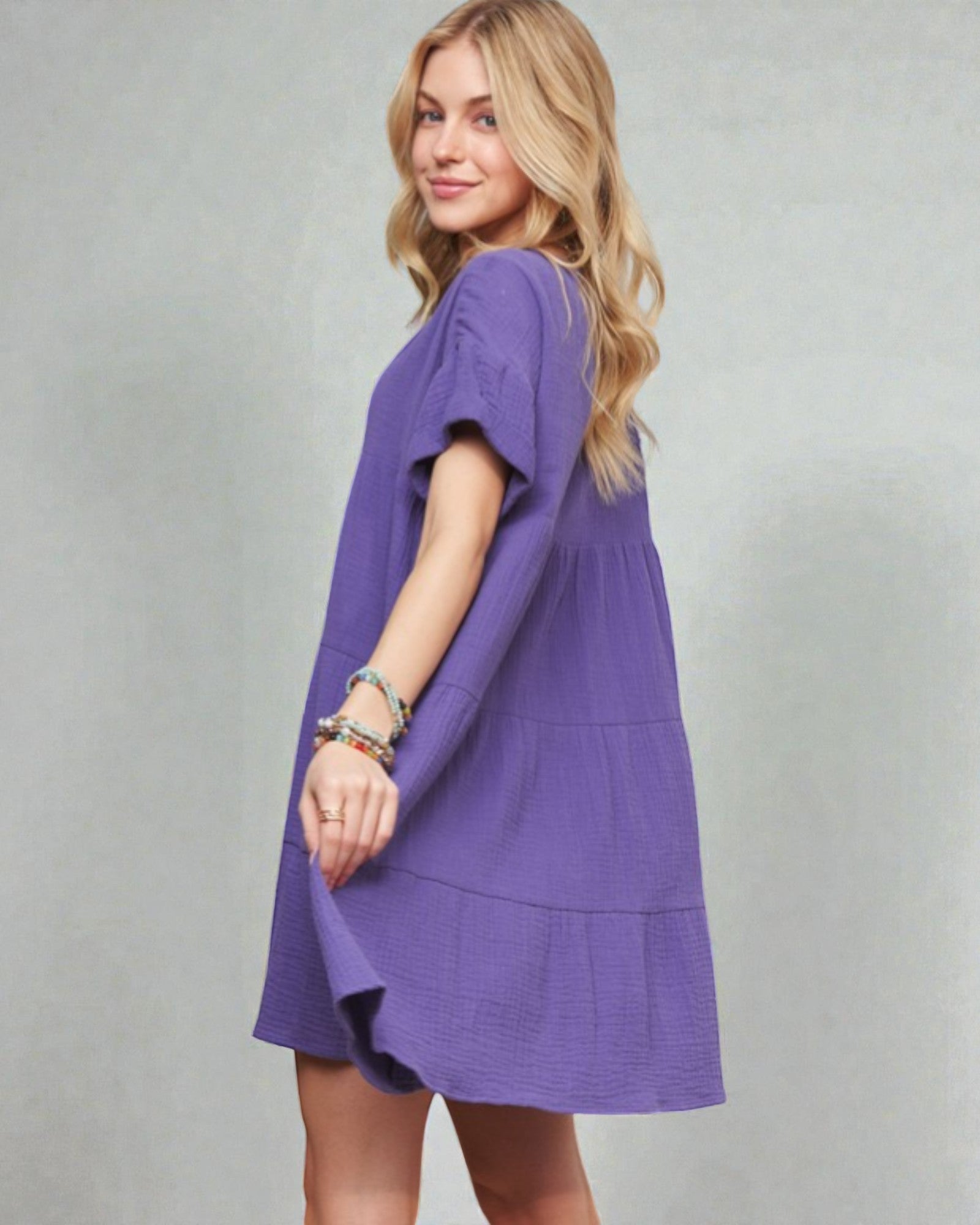 Woman wearing a purple dress against a plain background