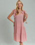 Woman wearing a pink dress with bow sleeves against a gray background