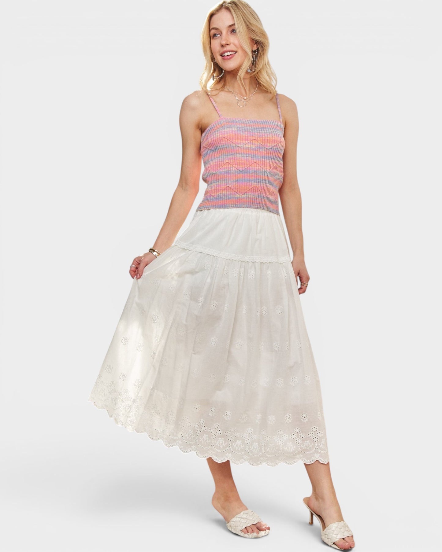 Woman wearing a striped top and white lace skirt on a white background