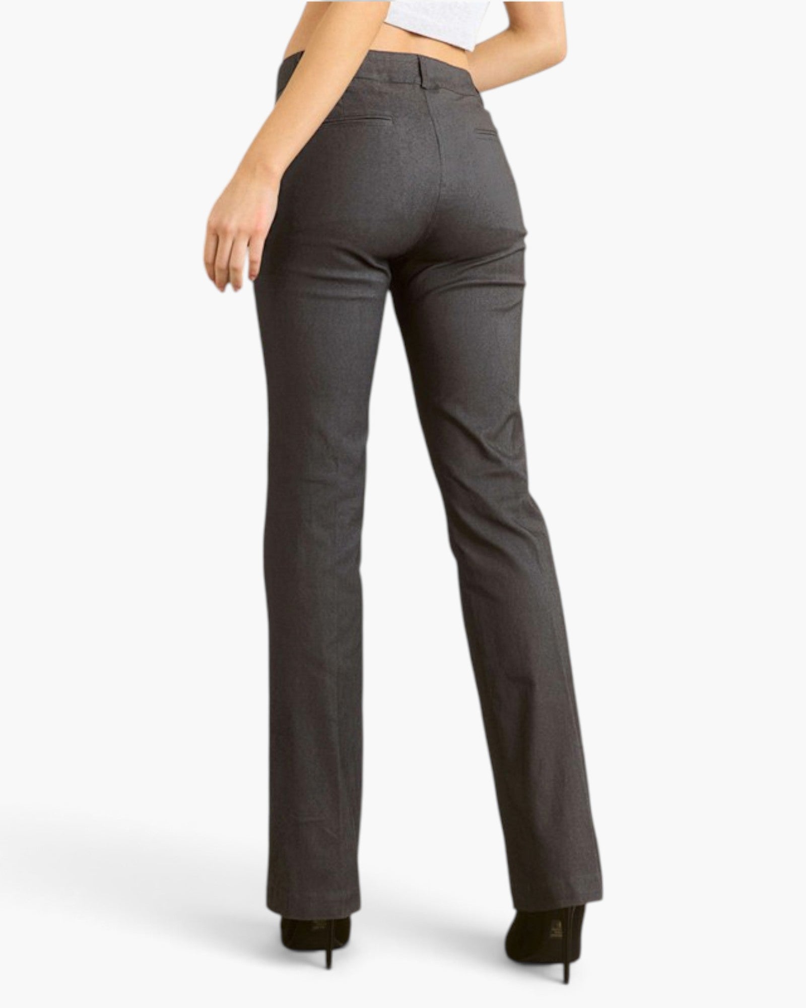 A model shown from the back wearing dark gray straight-leg jeans and black heels against a light gray studio background.