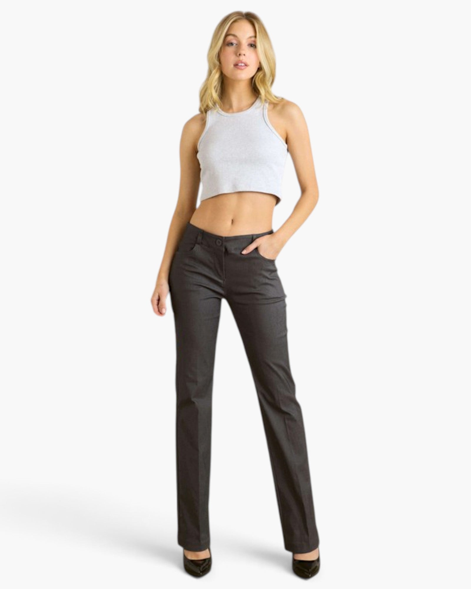 A woman modeling a pair of dark charcoal gray straight-leg jeans with a white ribbed halter crop top, standing against a light gray studio background.
