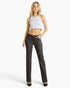 A woman modeling a pair of dark charcoal gray straight-leg jeans with a white ribbed halter crop top, standing against a light gray studio background.