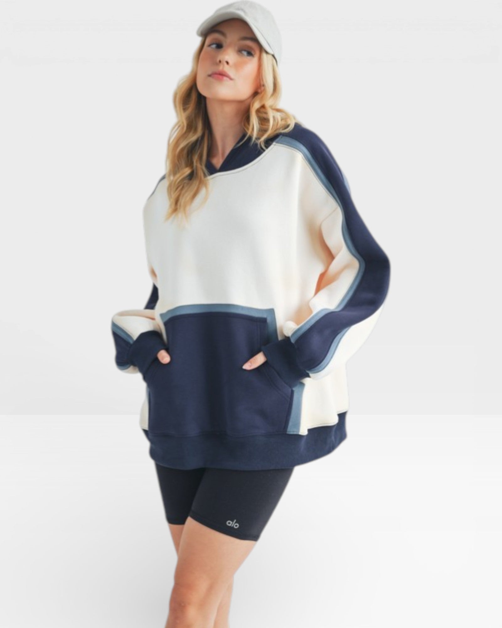 Woman wearing a navy and white color-blocked sweatshirt on a white background