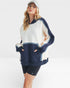 Woman wearing a navy and white color-blocked sweatshirt on a white background