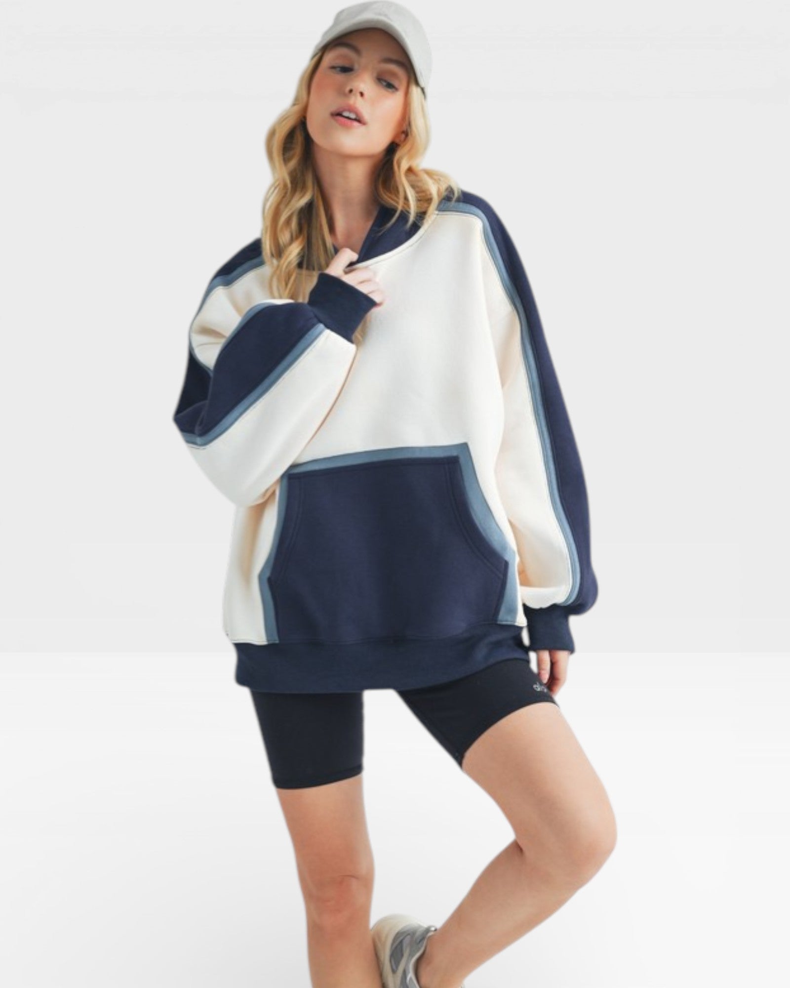 Woman wearing a navy and white striped hoodie with black shorts on a white background