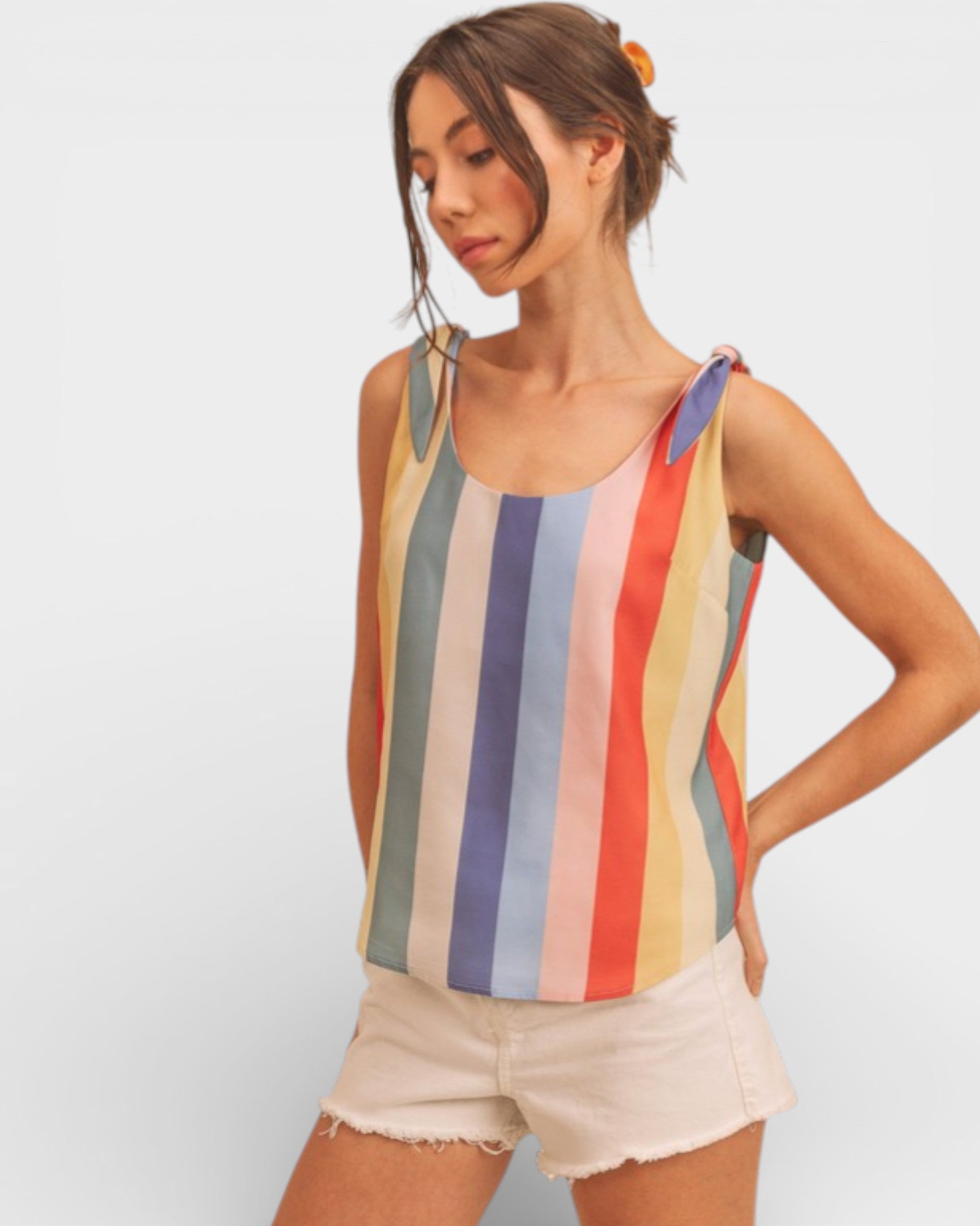 Woman wearing a colorful striped tank top against a plain background