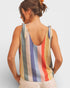 Woman wearing a multicolored striped tank top against a plain background