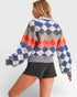 Person wearing a colorful diamond pattern sweater on a white background