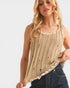 Woman wearing a beige knitted tank top with a white background