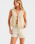 Woman wearing a beige sleeveless top and shorts set on a white background