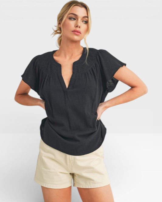 Woman wearing a black top and beige shorts on a white background