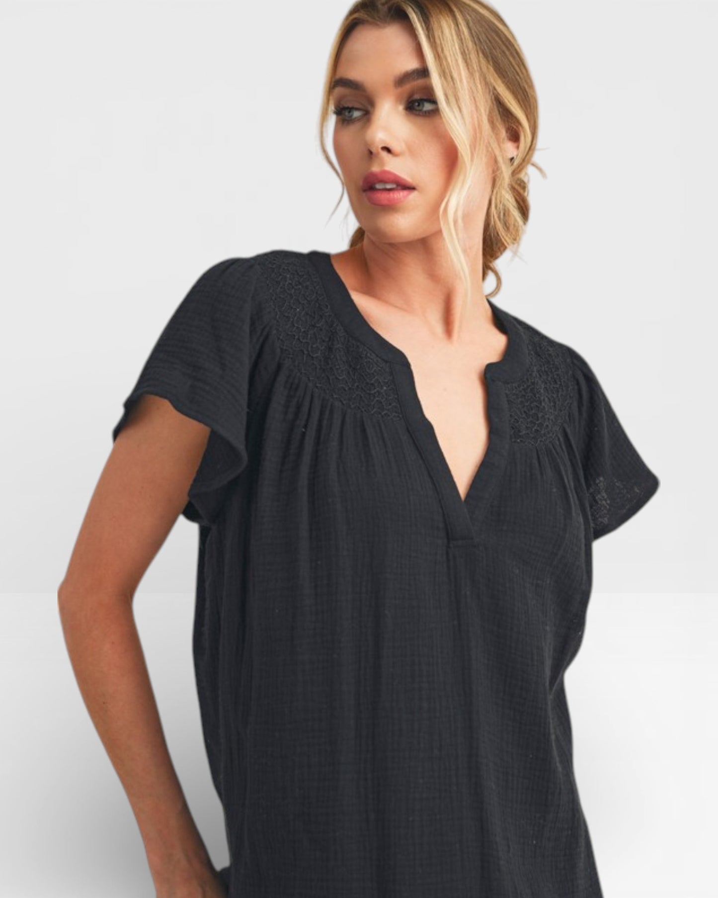 Woman wearing a black short-sleeve top against a white background