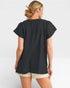Woman wearing a black top and beige shorts on a white background