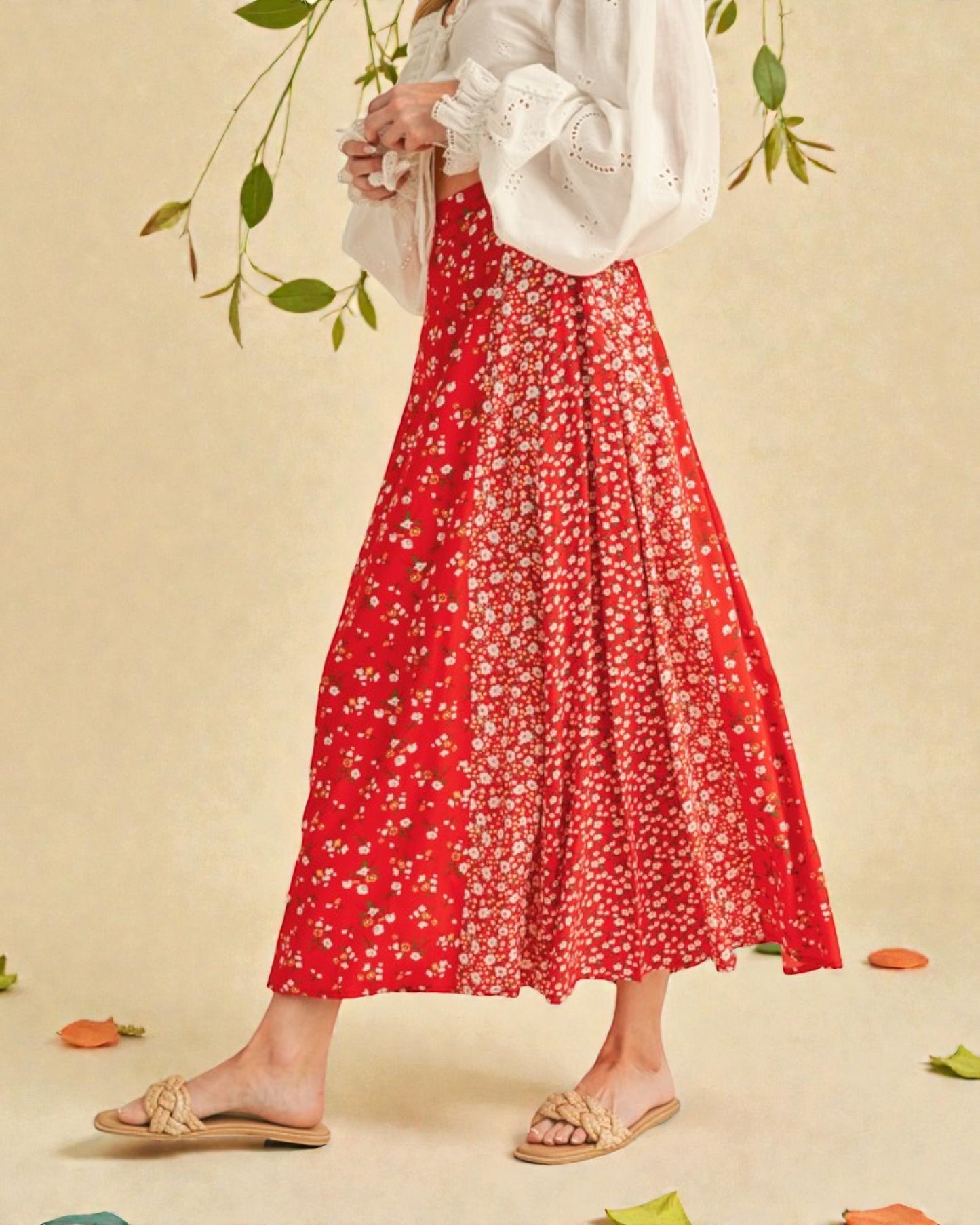 Person wearing a red floral skirt and white top on a beige background