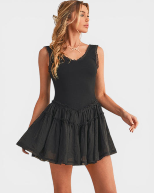 Woman wearing a black dress with a ruffled skirt on a white background