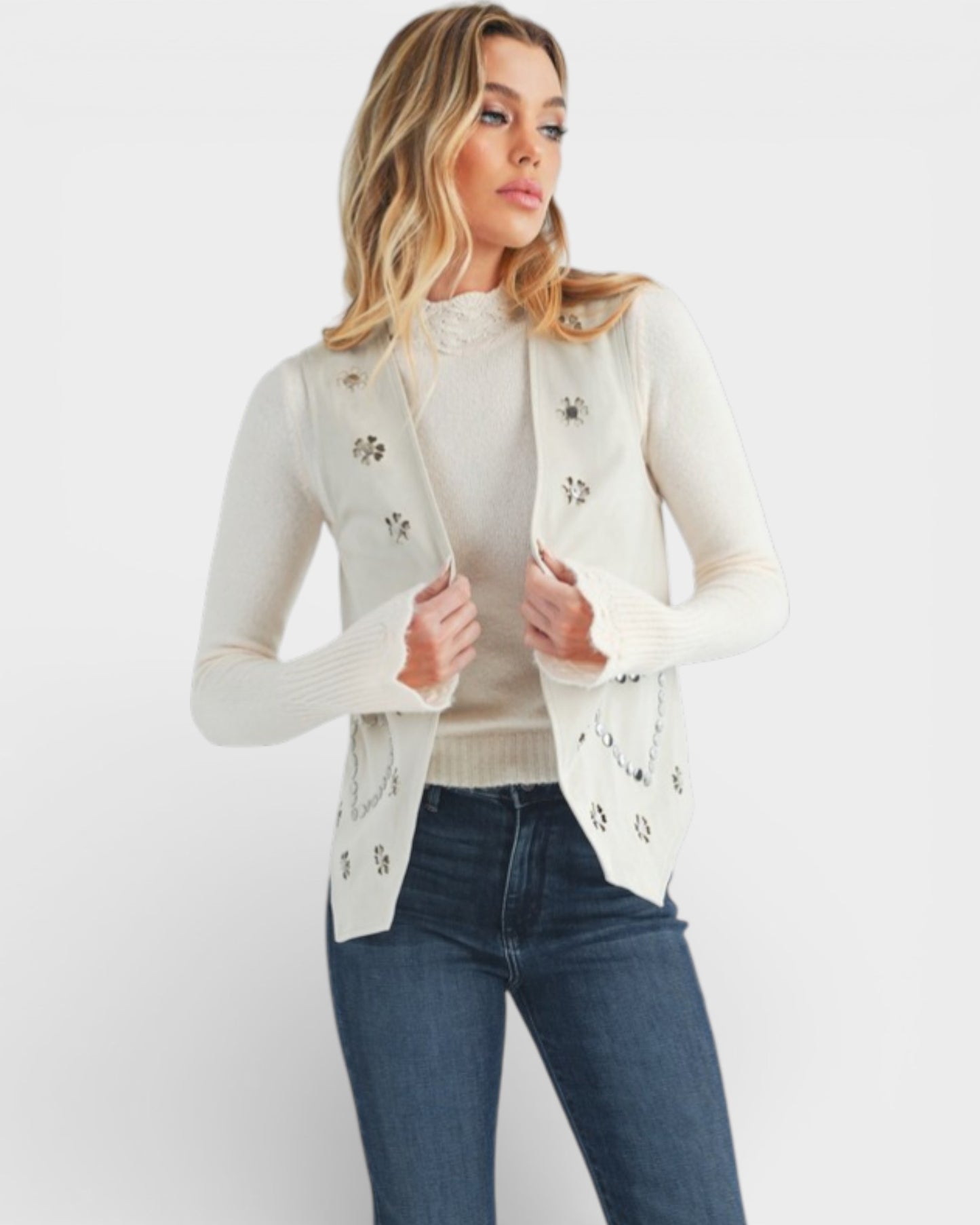 Woman wearing a light gray cardigan with floral embellishments on a white background