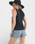 Woman wearing a black sleeveless top and denim shorts on a white background