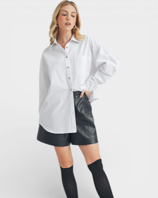 Woman wearing a white shirt and black leather shorts on a white background