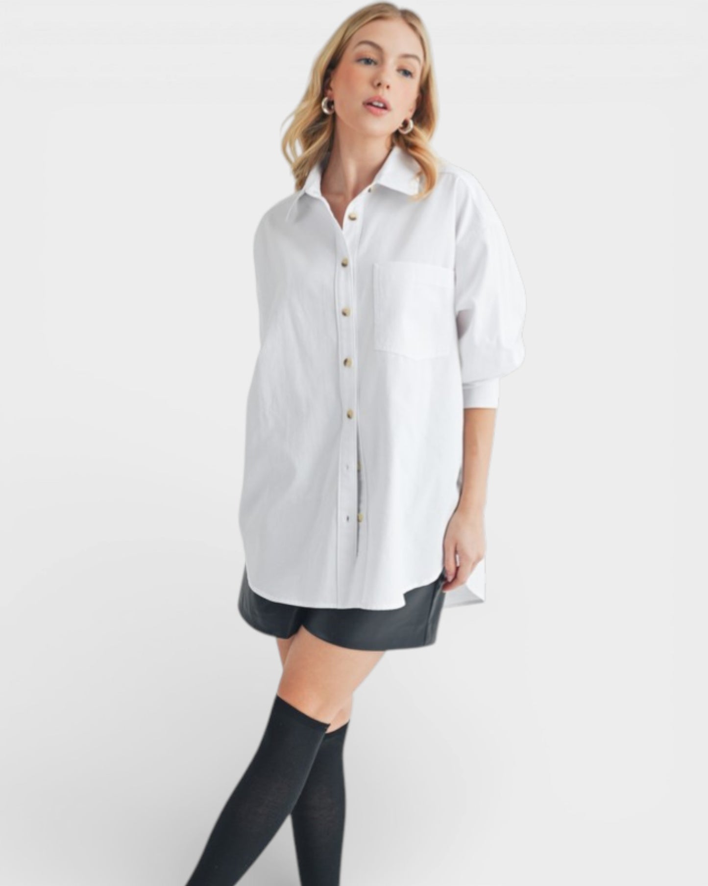 Woman wearing a white shirt and black shorts on a white background