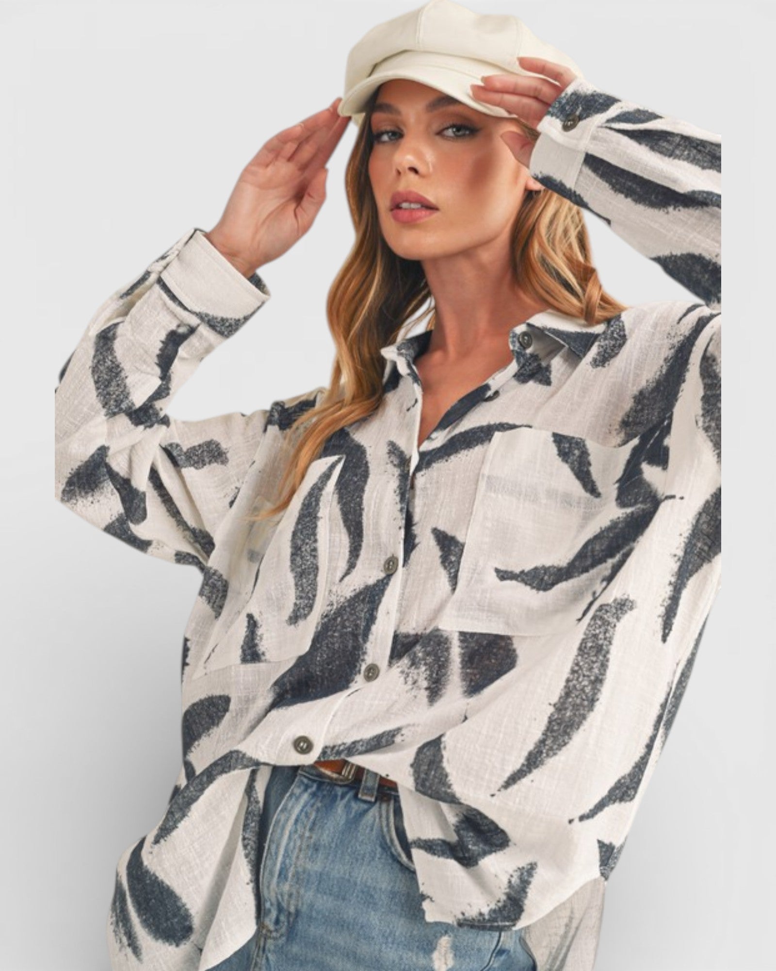 Woman wearing a patterned shirt and cap against a white background