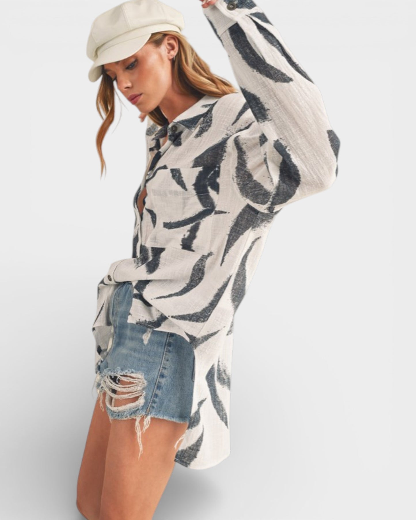 Woman wearing a patterned sweater and denim shorts on a white background