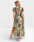 Woman wearing a patterned dress with a high slit on a white background