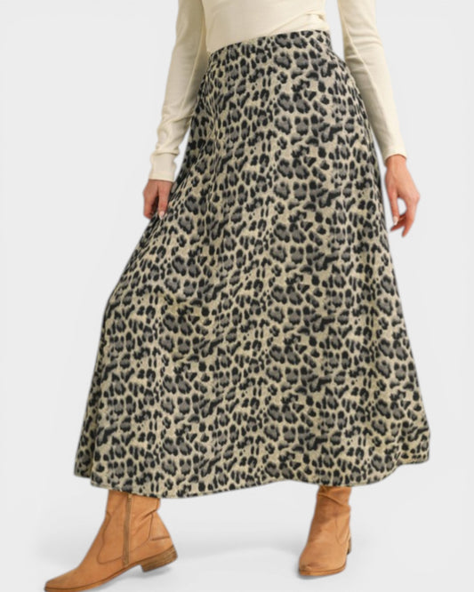 Person wearing a leopard print skirt with a plain background
