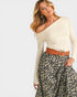 Woman wearing a white off-shoulder top and leopard print skirt with a brown belt.