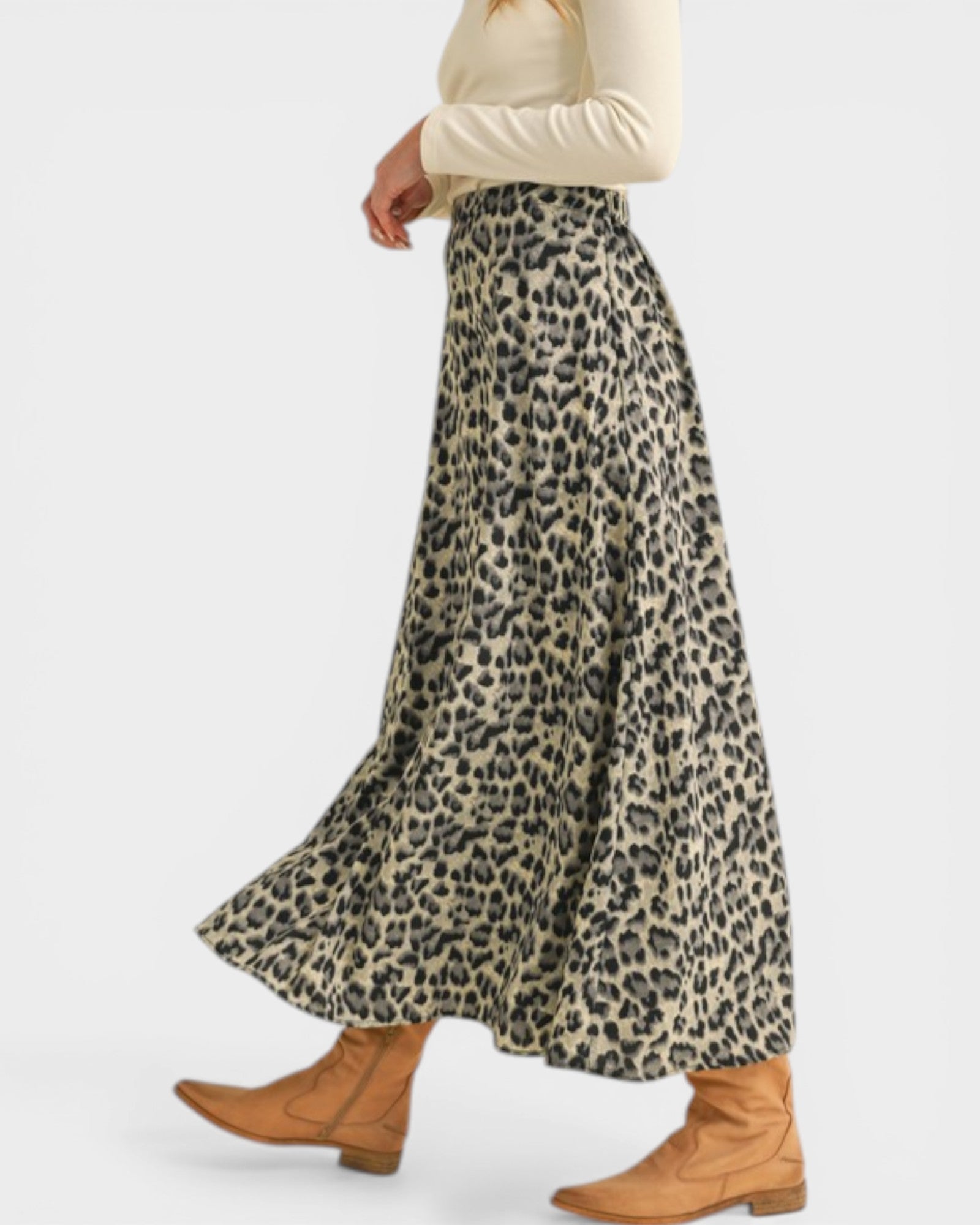 Person wearing a leopard print skirt with brown boots on a white background