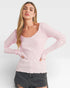 Woman wearing a pink ribbed sweater against a white background