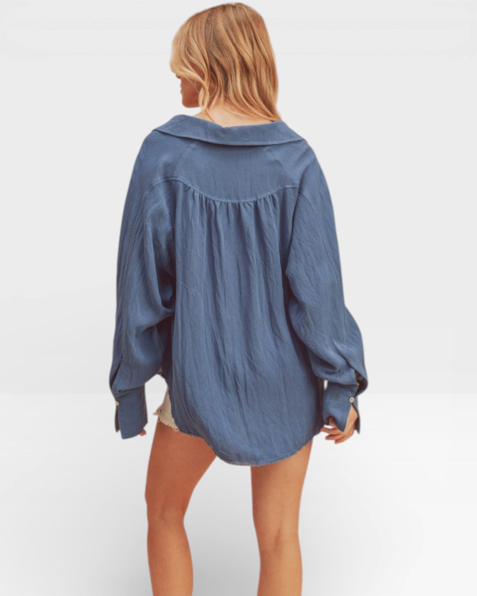 Person wearing a blue oversized shirt on a white background