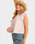 Woman wearing a light pink sleeveless top and straw hat on a white background