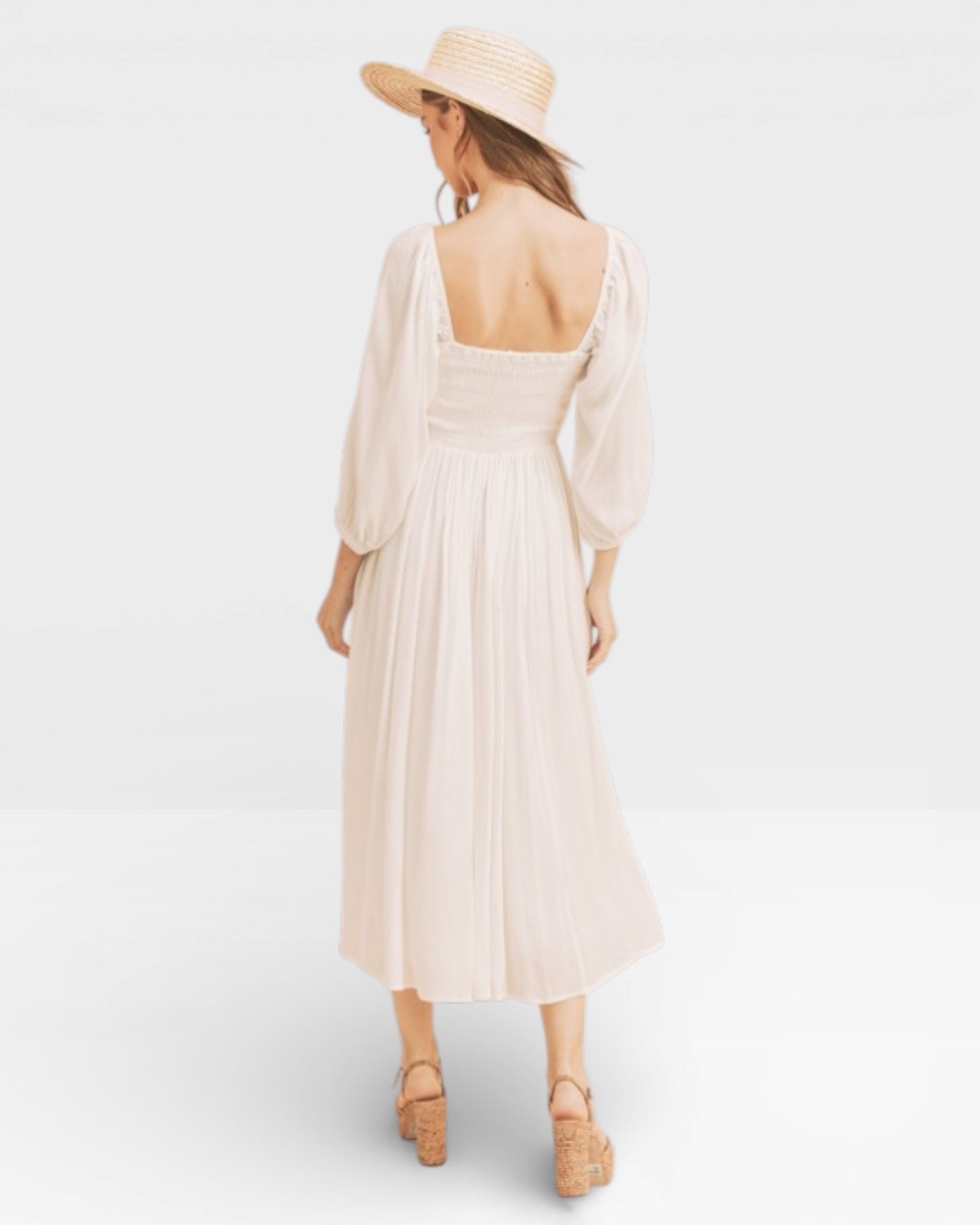 Woman wearing a beige dress and hat on a white background