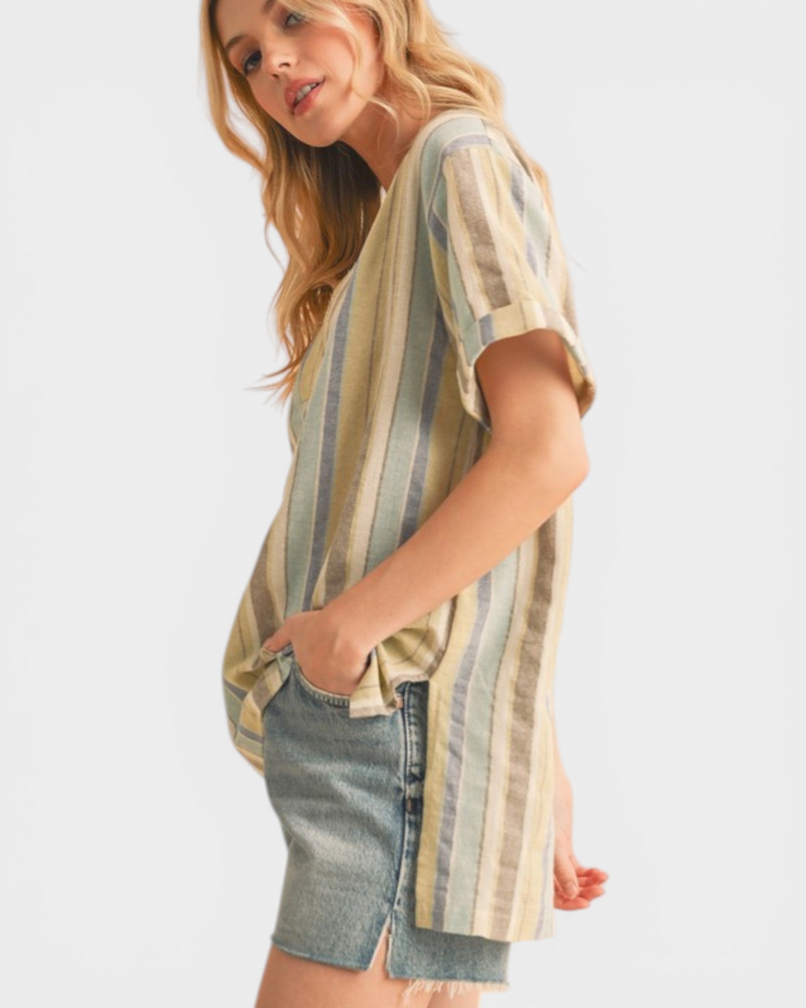 Woman wearing a striped shirt and denim shorts on a white background