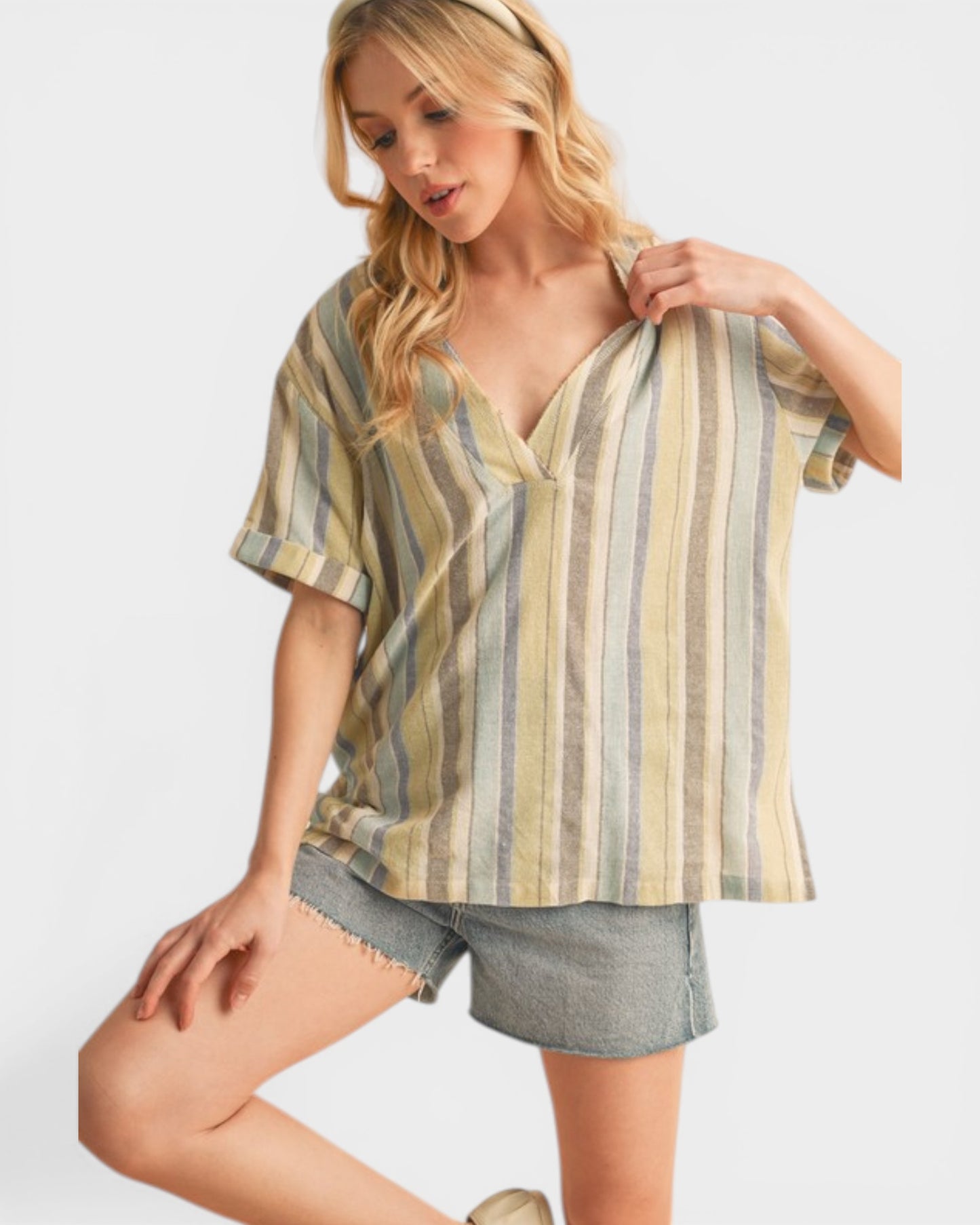 Woman wearing a striped shirt and shorts on a plain background