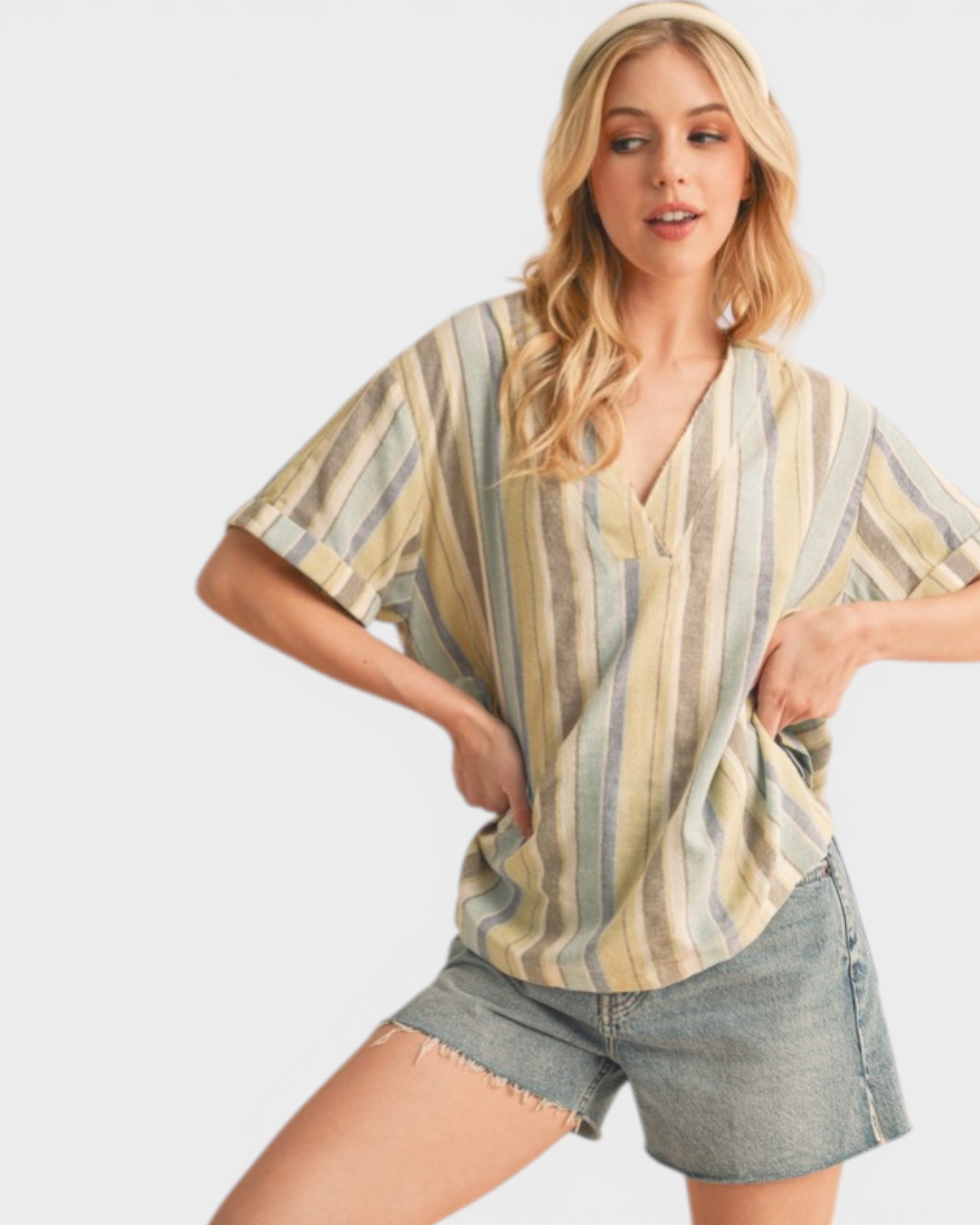 Woman wearing a striped shirt and denim shorts on a white background