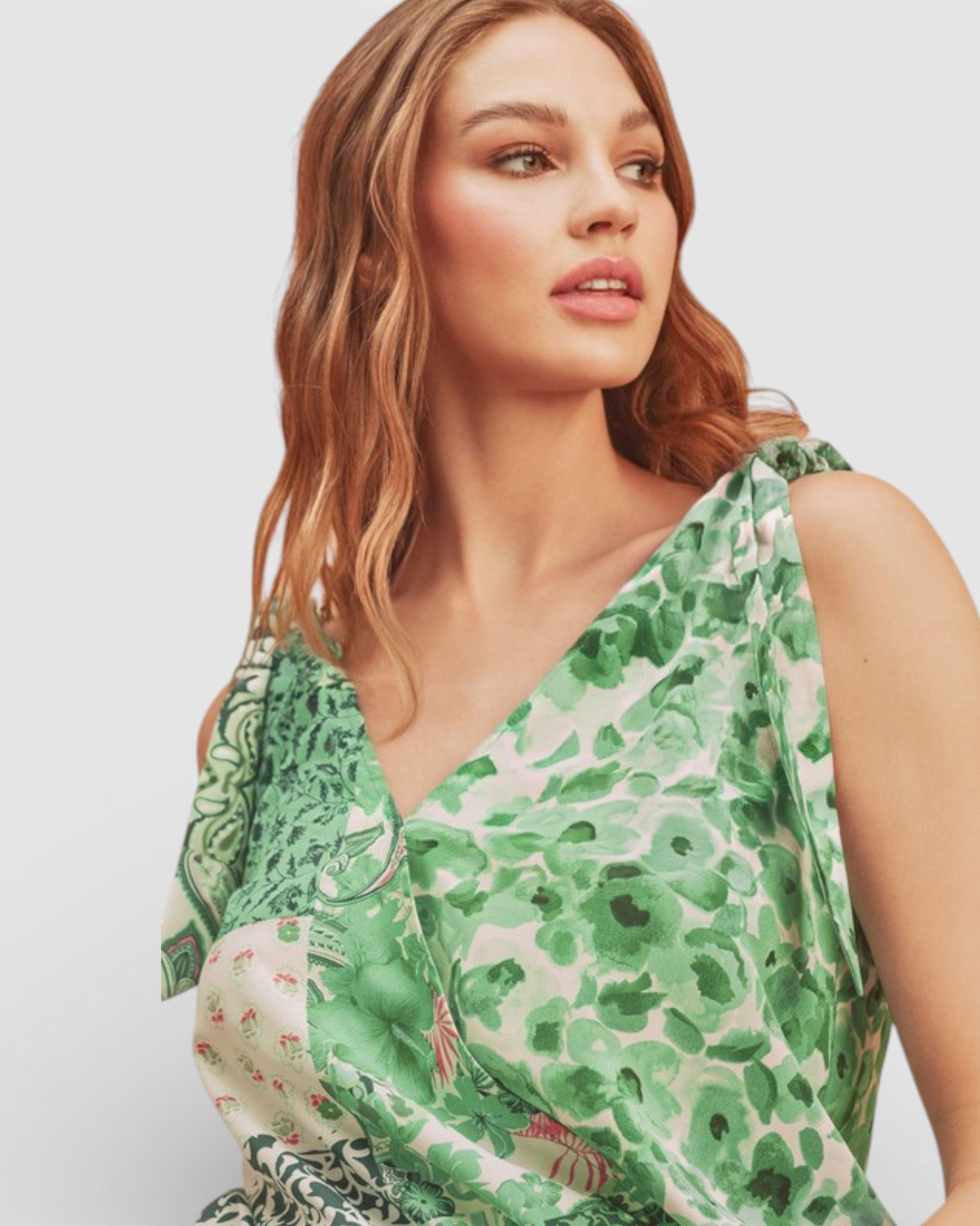 Woman wearing a green floral dress against a plain background